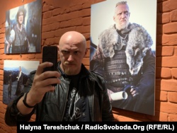 Актор Олег Волощенко робить селфі біля своєї фотографії з фільму