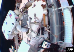 Двоє американських астронавтів, Шейн Кімбро та Пеґґі Вітсон, встановлюють проміжкові пластини та електричні контакти літій-іонних батарей на Міжнародній космічній станції, січень 2017 року