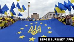 Молодь тримає прапор Євросоюзу з гербом України на майдані Незалежності в Києві, 30 жовтня 2013 року