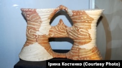 Біноклевидна керамічна посудина, яка дуже подібна до українських подвійних глечиків. У яких ще сто років тому українські селяни носили на поле обід