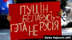 Під час акції солідарності з білоруським народом у столиці Сербії. Жінка тримає плакат із написом «Путін, Білорусь – це не Росія». Белград, 9 вересня 2020 року